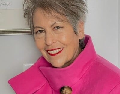 Headshot of Theresa smiling and wearing pink sweater