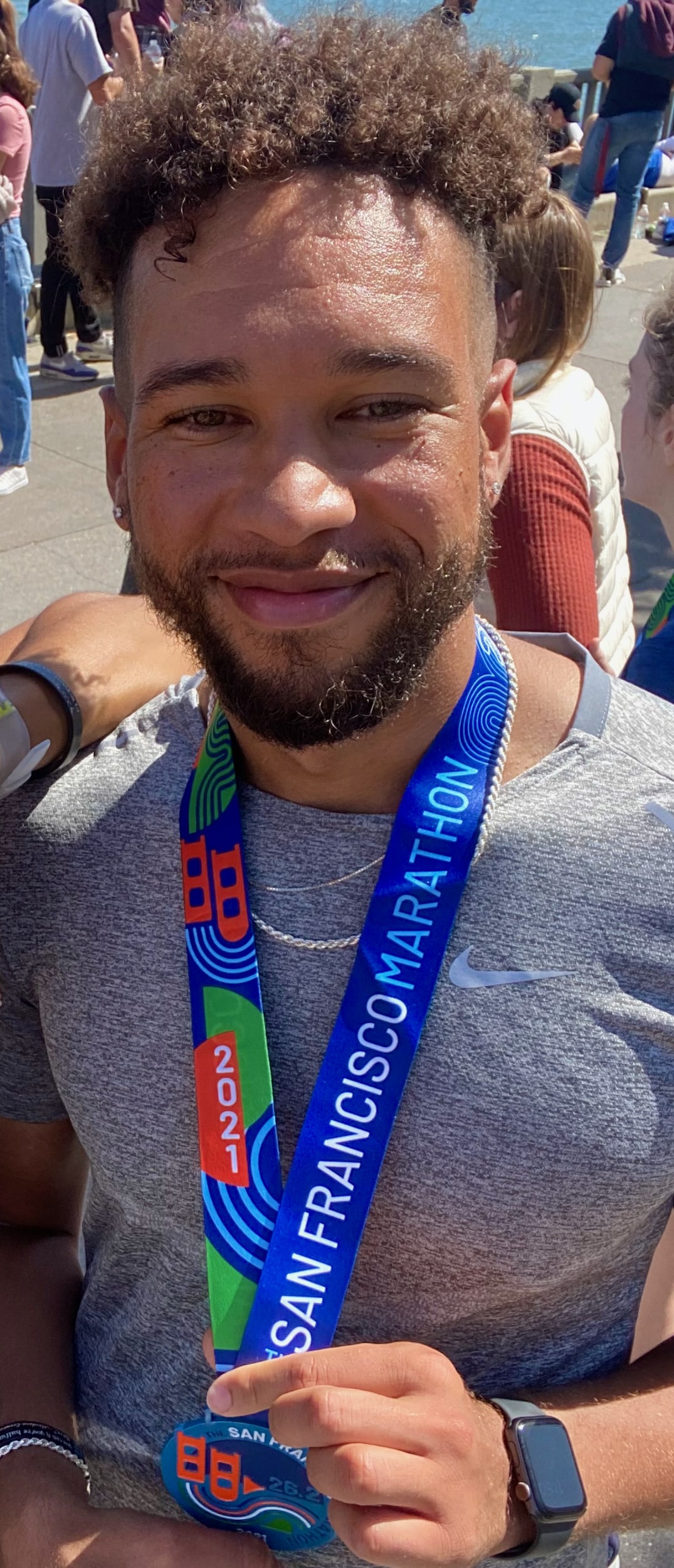 Damian with a medal around his neck after running marathon