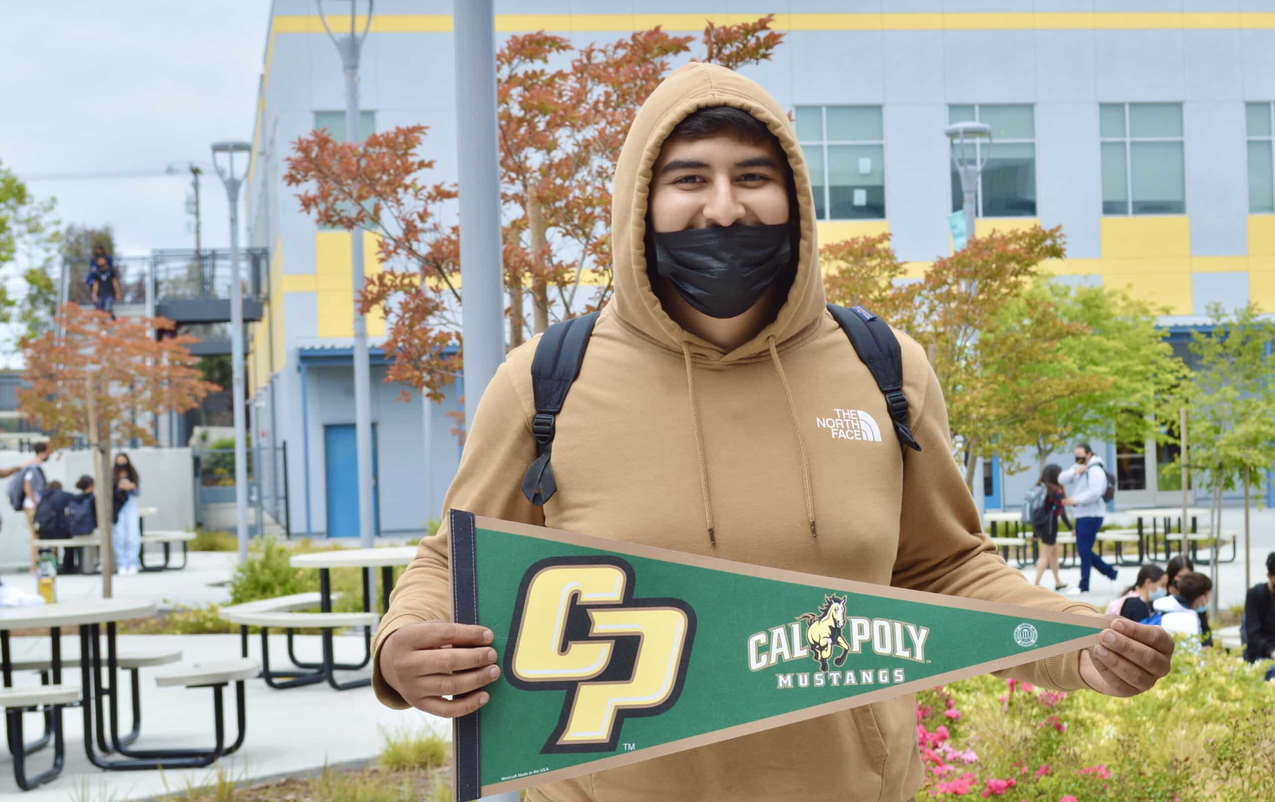 Making Waves Academy student holding Cal Poly flag