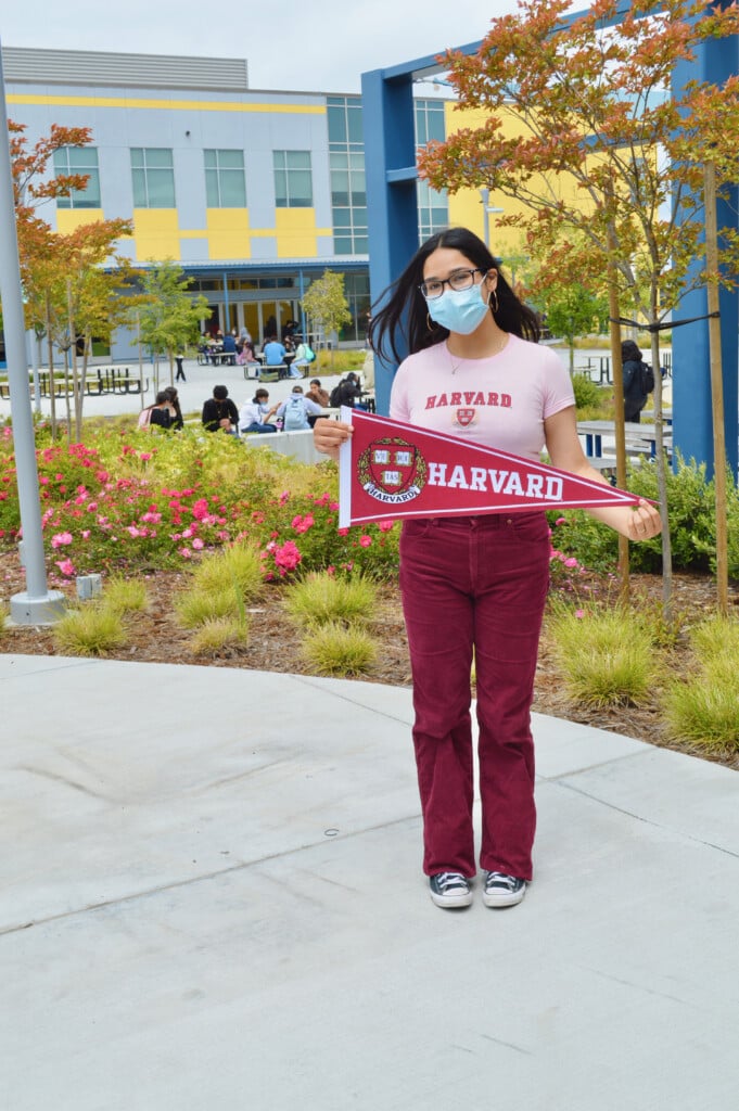 Lizbeth on campus holding Harvard sign