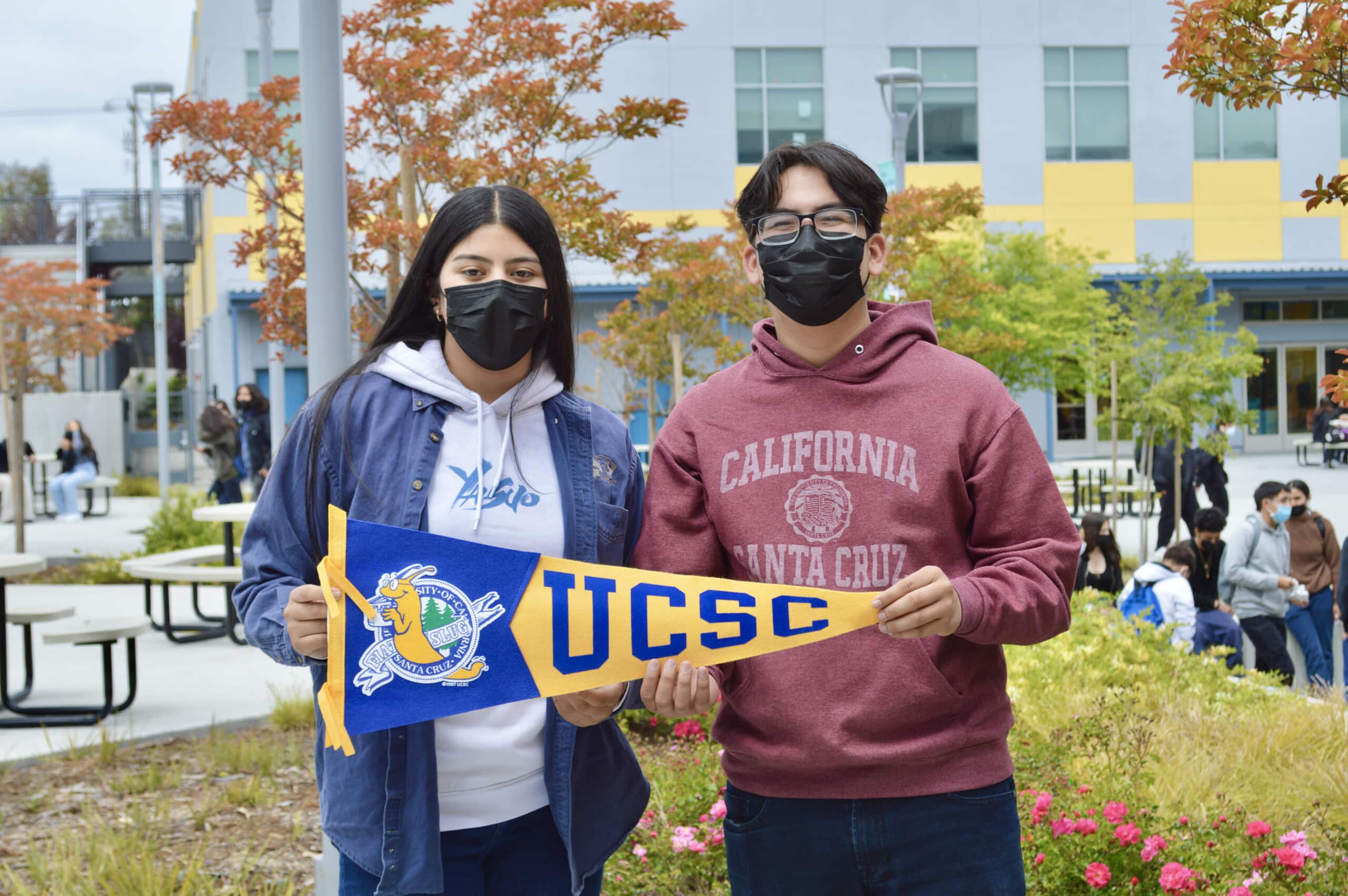 Students at Making Waves Academy holding UC Santa Cruz flag