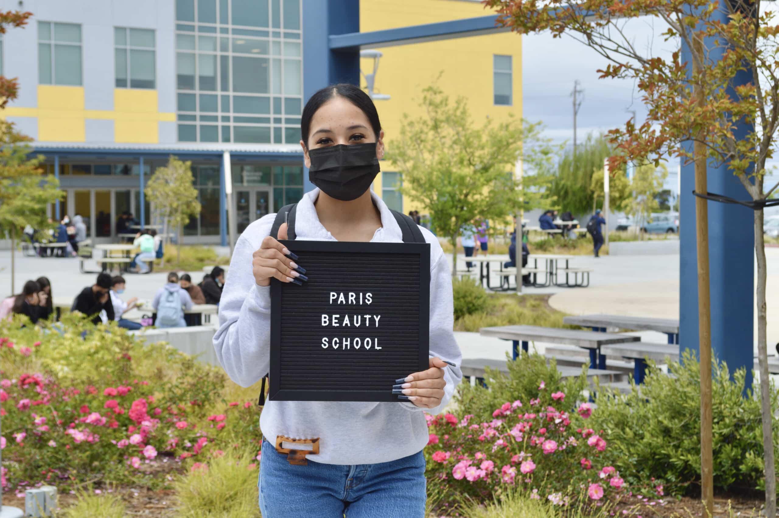 Making Waves Academy student holding Paris Beauty School sign