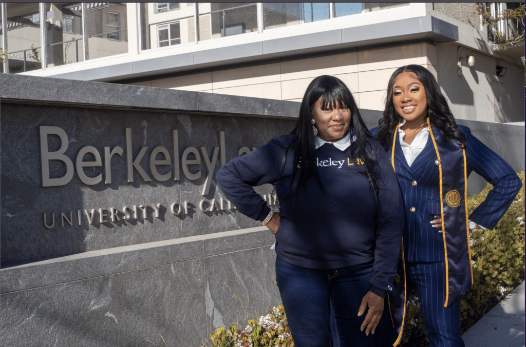 Leaje and her mother in UC Berkeley attire in front of Berkeley sign