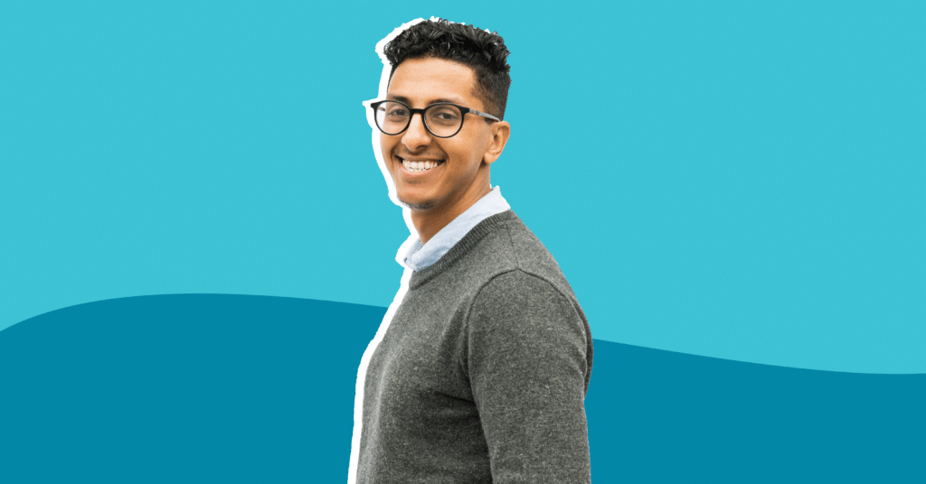 Photo of Hossain Albgal with a grey sweater and a dark and light blue background