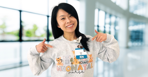 Neonatal Nurse Grace Zhang wears a Neonatal sweatshirt and RN hospital badge