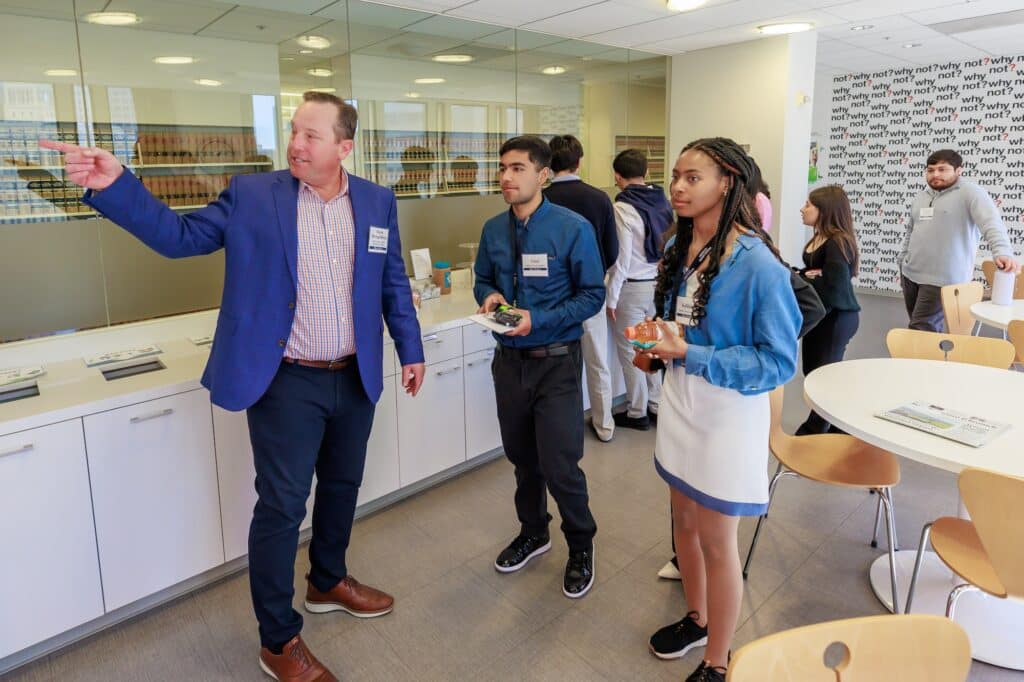 Lawyer pointing showing students around law office