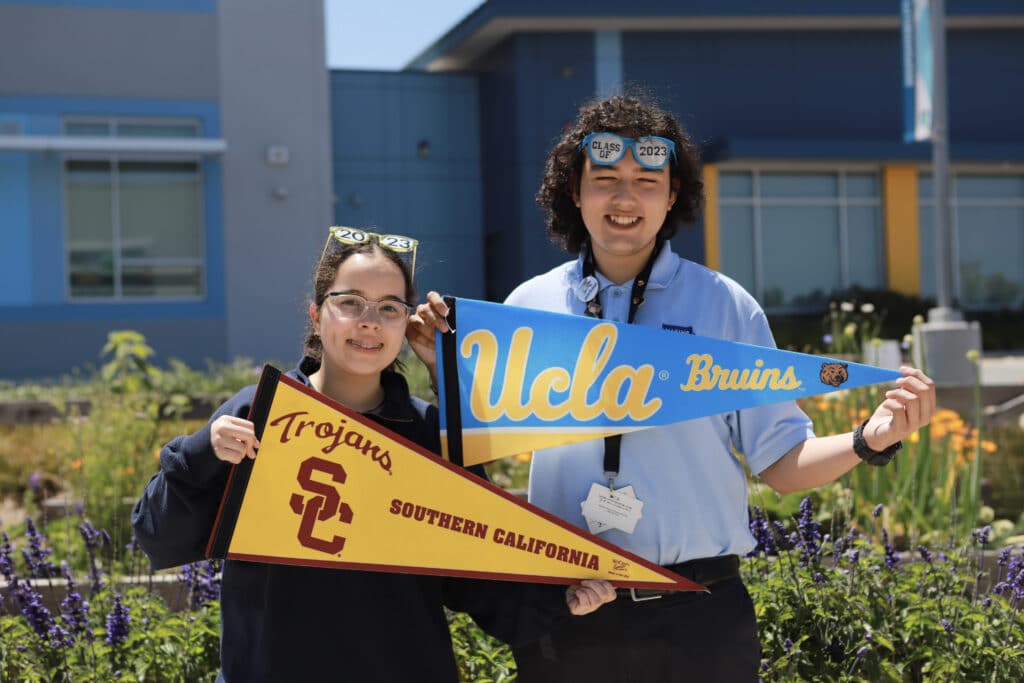 Student holding USC flag and student holding UCLA flag