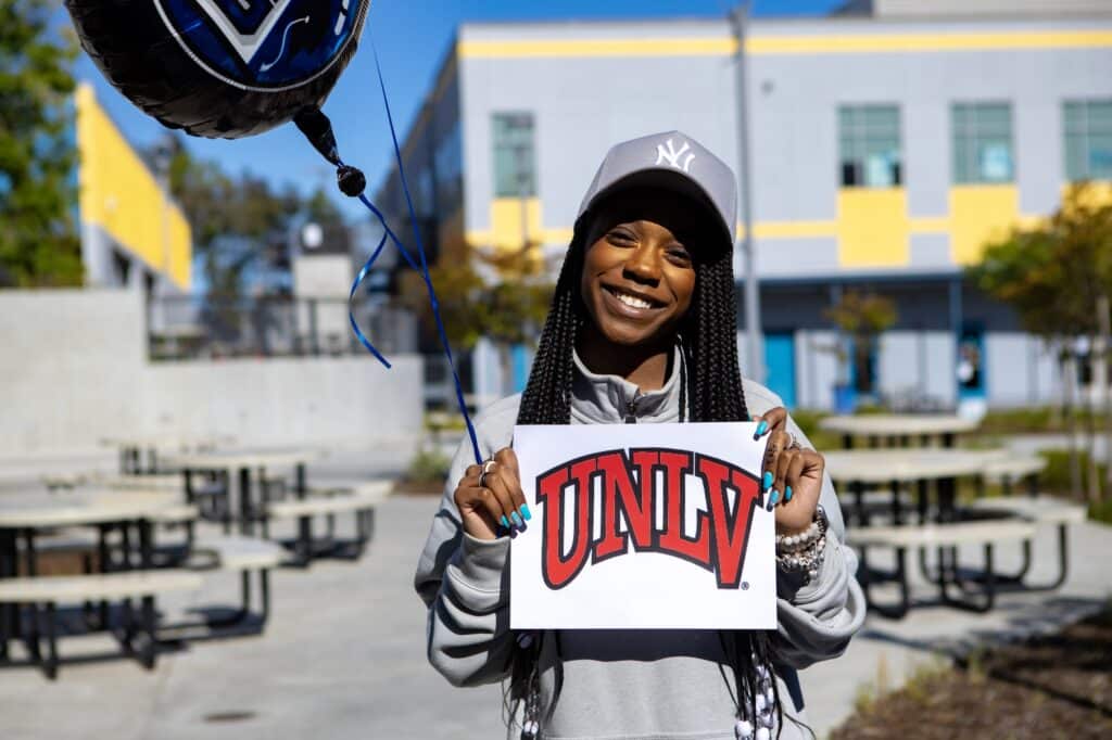Student holding balloons and sign for UNLV