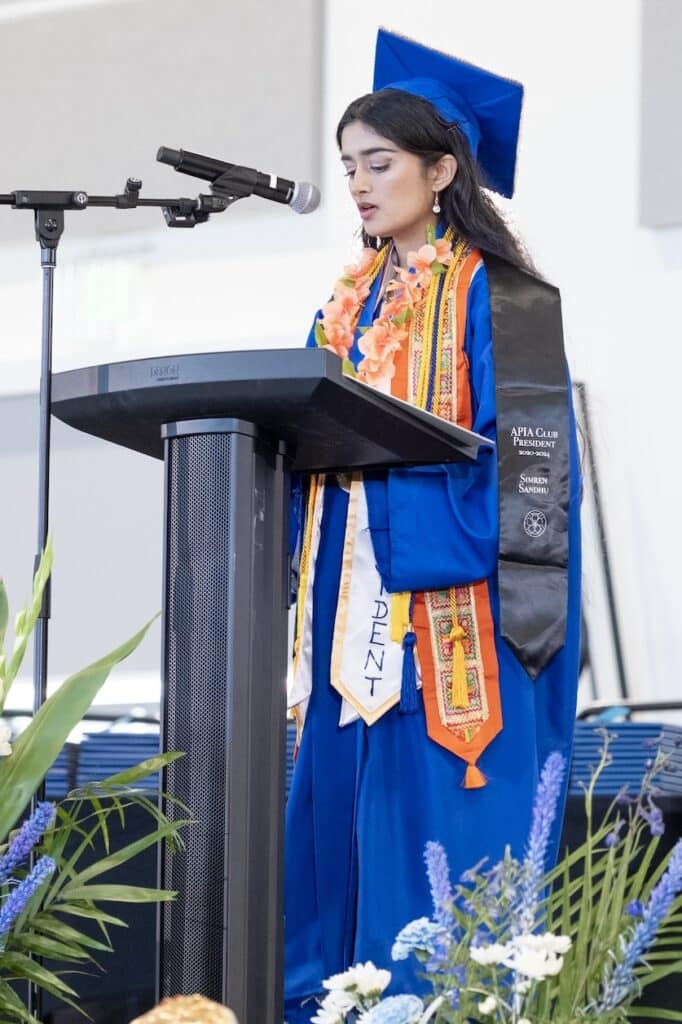 Student speaking on stage at podium