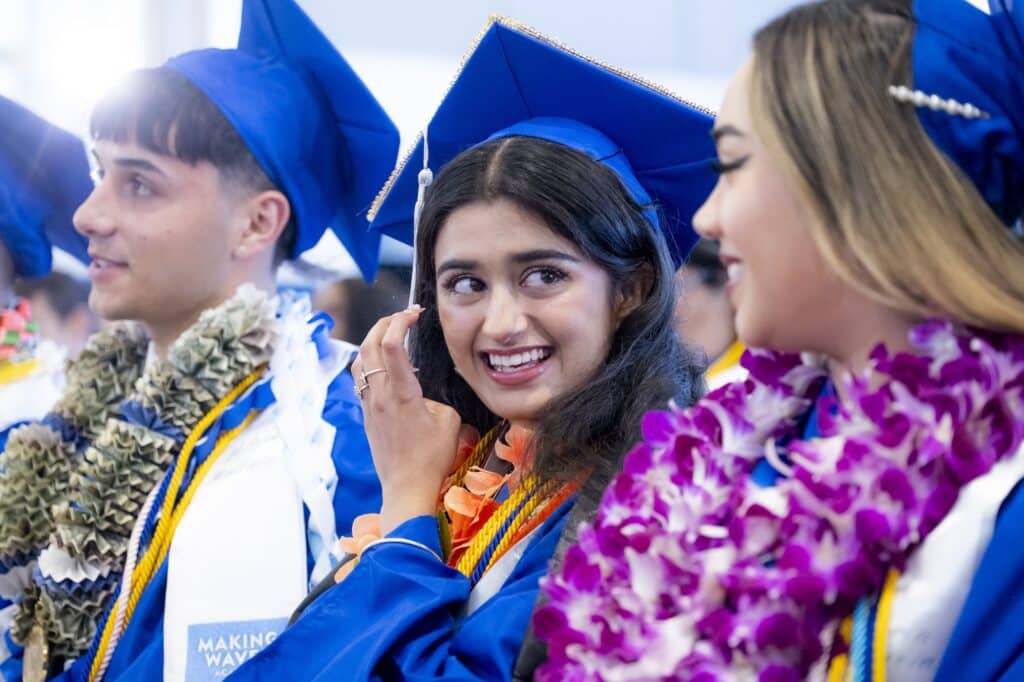 Student smiling in blue caps and gowns