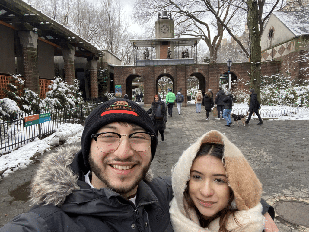 Estefan Cervantes andgirlfriend wearing warm coats in front of central park zoo wit snow outside