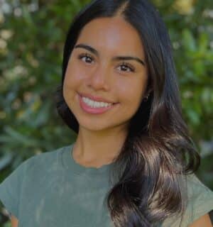 Ashley Ramirez smiling with greenery behind her