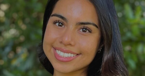 Ashley Ramirez smiling with greenery behind her