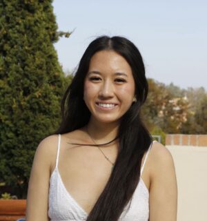 Photo of Anna Vo smiling with greenery in background